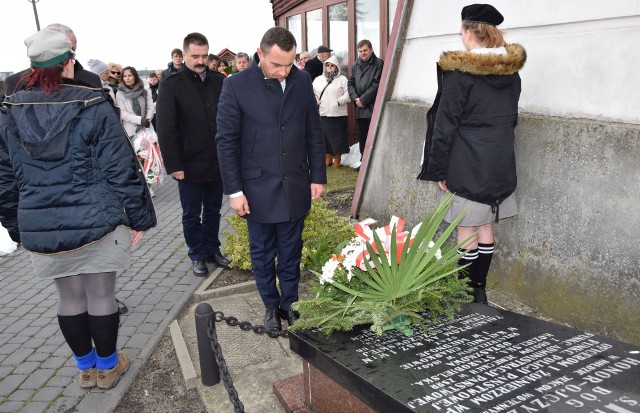 Burmistrz Włoszczowy Grzegorz Dziubek składa kwiaty przy symbolicznej mogile katyńskiej na cmentarzu.