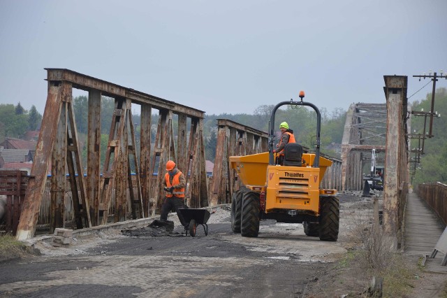Na starym moście w Cigacicach rozpoczęły się już pierwsze prace związane z remontem. Obecnie z obiektu jest ściągana dawna nawierzchnia, która również ulegnie wymianie przy modernizacji przeprawy. Most zamknięty do końca 2021 roku Przypomnijmy, pod koniec lutego podpisano umowę na remont mostu w Cigacicach z konsorcjum dwóch firm z Wrocławia, PBW Inżynieria i Probudowa.com. Oficjalnie most jest zamknięty dla mieszkańców regionu już od 15 kwietnia. W ostatnich dniach odwiedziliśmy plac budowy. Na terenie obiektu pojawili się już pierwsi robotnicy, którzy rozpoczęli modernizację od ściągnięcia starej nawierzchni. Co ciekawe nie wszyscy wiedzą, że przeprawa jest niedostępna. Byliśmy świadkami, jak kierowcy dojeżdżali do mostu w Cigacicach i musieli zawracać, aby pokonać Odrę przy pomocy drogi S3.Oficjalnie inwestycja ma zakończyć się do listopada 2021 roku. Całkowity koszt prowadzonych prac oszacowano na 12 mln zł. 80 proc. tej sumy zostanie pokryte z dotacji celowej premiera Mateusza Morawieckiego, resztę dołoży urząd miasta w Zielonej Górze oraz powiat zielonogórski.Historia mostu w CigacicachStary most w Cigacicach został otwarty 29 kwietnia 1925 r. Powstał w Zakładzie Konstrukcji Stalowych i Mostowych Beuchelt & Co. w Zielonej Górze. Jego historia bywała burzliwa. W 25 stycznia 1945 r. jedno z przęseł mostu zostało wysadzone przez niemieckie wojska, które chciały zatrzymać rosyjskie czołgi na linii Odry. Zniszczenie zostały naprawione w latach 50. ubiegłego wieku. W ostatnich latach przeprawa ulegała stopniowej degradacji aż w końcu władze Zielonej Góry nie miały innego wyjścia, jak ograniczyć możliwość przejazdu przez most dla cięższych pojazdów. Warto wiedzieć, że od czasu połączenia miasta z gminą to właśnie zielonogórski magistrat odpowiada za administrację i opiekę nad starą przeprawą w Cigacicach. Wideo: Zielona Góra. Dziki w mieście - filmy nadesłane przez czytelnika Gazety Lubuskiej