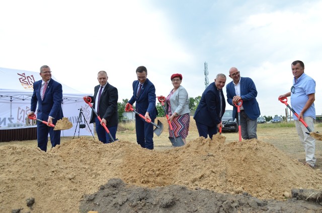 Praca na budowie pierwszego od 28 lat bloku komunalnego w Żninie wre.Blok ma stanąć na wylocie ze Żnina w kierunku Murczyna, między budynkiem wykorzystywanym przez "Trójkę", a stojącymi tam kilkadziesiąt lat blokami. Zanim przy dźwiękach trąbek oficjele wbili pierwszą symboliczną łopatę  w miejsce budowy, głos zabrali burmistrz Robert Luchowski, szef wydziału inwestycji żnińskiego ratusza Paweł Piechowiak i przewodniczący komisji mieszkaniowej i zarazem radny Tomasz Wysocki. Fragment przemówienia burmistrza Roberta Luchowskiego:W bloku ma być osiemnaście mieszkań, przeznaczonych dla osób, które obecnie zajmują już mieszkania komunalne w innych częściach miasta. Budowa ma odbyć się na tyle szybko, że zimą inwestycja ma być prawie ukończona. - Przystąpiliśmy już do robót. Mamy plan do końca czerwca zalać ławy fundamentowe i do końca lipca jak to się mówi "wyjść z ziemi", czyli piwnice będą zrobione. Sądzę, że organizacyjne powinniśmy podołać, ze względu na to, że mamy dwa place budowy w jednym miejscu. Chcemy, żeby do okresu zimowego nastąpiło zamknięcie budynku - powiedział Andrzej Teska z szubińskiej firmy Dom, która buduje obiekt.  Przeczytaj także: Umowa na budowę bloku komunalnego w Żninie podpisana. Prace mają ruszyć jeszcze w tym miesiącuHappening "Święto ulicy Śniadeckich" w Żninie [zdjęcia] Moment inauguracji budowy: