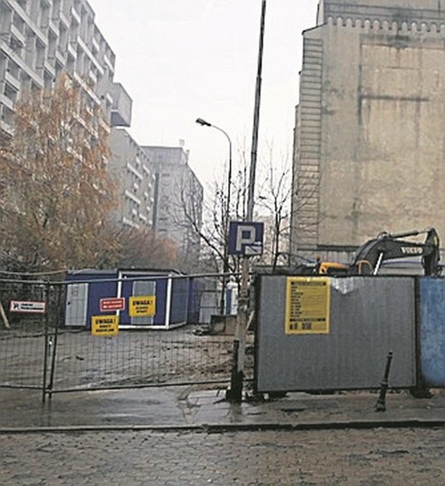 Przez siatkę ogrodzenia można dojrzeć wielki wykop.