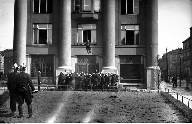 Strażak skacze z okna budynku „IKC” na rozciągniętą płachtę podczas pokazu ewakuacji z zagrożonych miejsc, 1929. Koncern „Ilustrowany Kuryer Codzienny”
