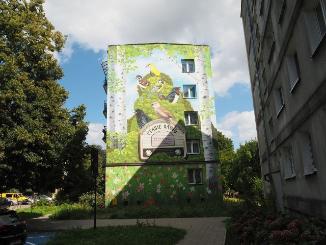 Mural został odsłonięty w czwartek, 25 sierpnia na ścianie bloku przy ul. Szpitalnej 7a, nieopodal Państwowej Szkoły Muzycznej 1 st. im. Aleksandra Tansmana. CZYTAJ WIĘCEJ NA KOLEJNYCH SLAJDACH!