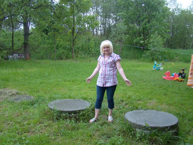 Teresa Zacharska z Brodów w gminie Kalwaria Zebrzydowska pokazuje włazy do szamba. Gdy zbiorniki są już pełne, kolejne ścieki zatrzymują się w rurach i zalewają mieszkania na parterze domu