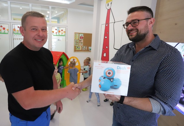 Kamil Chamerski z firmy Mac (z prawej) wręcza Tomaszowi Kucharczykowi z przedszkola Kids College robota marki Dash.