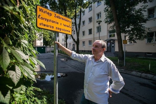 Damian Grabowski przy jednej z tablic ostrzegających o niebezpieczeństwie.