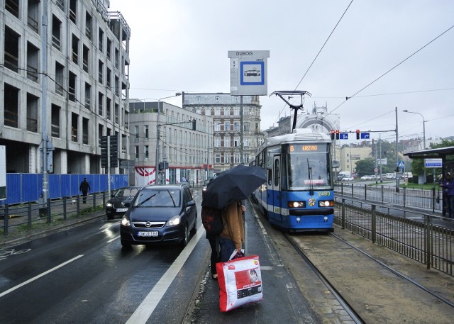 Przystanek "Dubois". Pasażerowie z parasolami ledwo się mieszczą na maleńkiej wysepce.