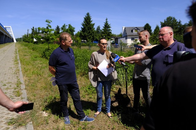 Sylwia Kowalska i Maciej Cichowicz podczas konferencji pod toruńskim mostem. Za nimi wykopany pień drzewa i miarka