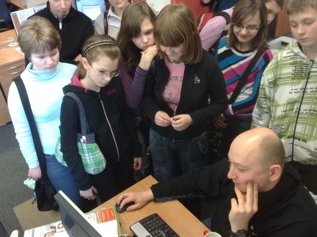Fotoreporter Witold Chojnacki opowiada uczniom o swojej pracy.