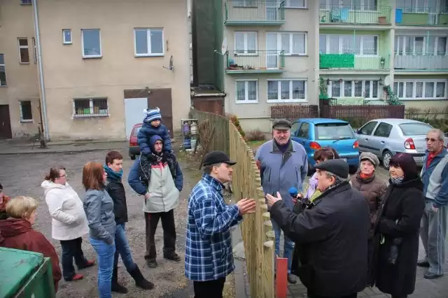 Osaczeni lokatorzy (z lewej) podeszli wczoraj "do płota&#8221;, by wyjaśnić z sąsiadami sytuację. Zamiast porozumienia doszło jednak do awantury, która jeszcze bardziej podzieliła mieszkańców.