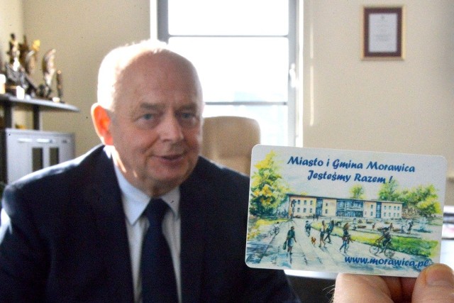 Burmistrz Marian Buras prezentuje gminną kartę rabatową.