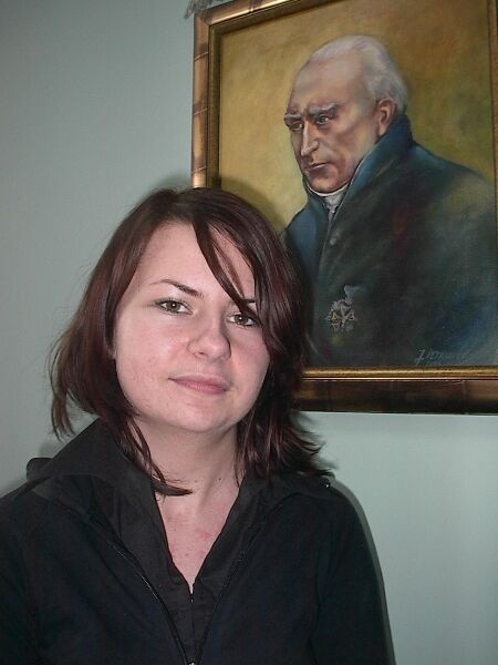 Paulina Powązka z Włoszczowy na tle portretu patrona swojej szkoły Stanisława Staszica.
