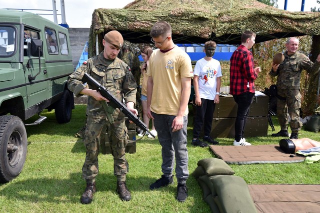 II Piknik Patriotyczno-Edukacyjny – Pacanów 2023. Żołnierz Wojsk Obrony Terytorialnej prezentuje jednemu z ósmoklasistów karabinek MSBS, który od 2017 roku zastępuje w Wojsku Polskim broń strzelecką systemu Kałasznikowa.