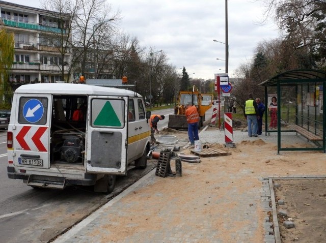 Drogowcy układają nowy chodnik z kostki na przystanku przy ulicy Żwirki i Wigury, za skrzyżowaniem z ulicą Kusocińskiego.