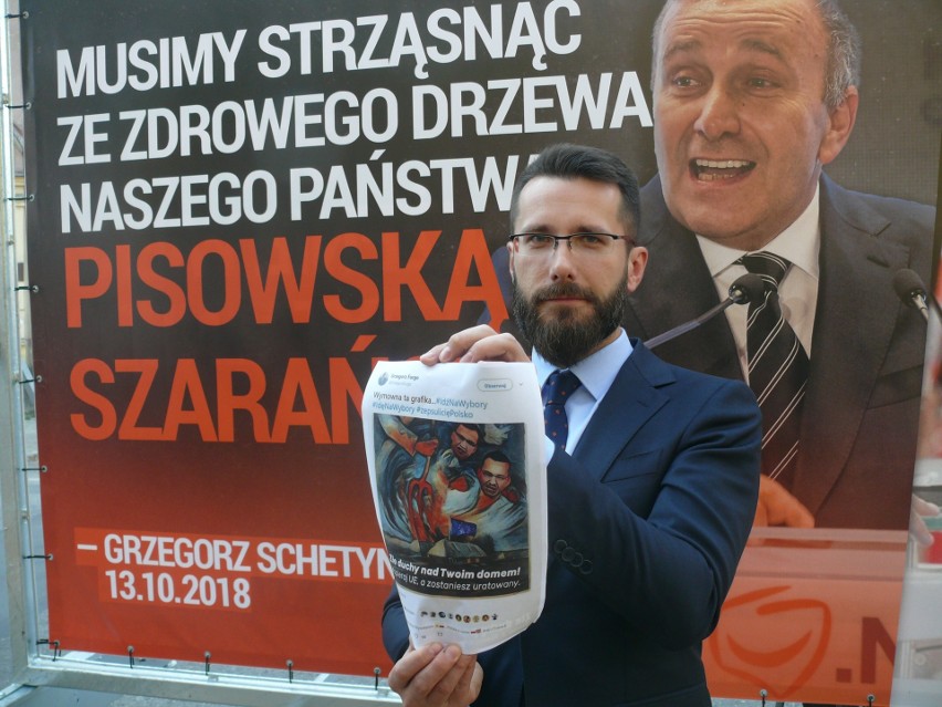 Radny Radosław Fogiel  z plakatem przeciwników.