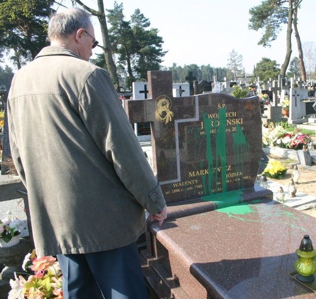 Pan Andrzej pokazuje oblany olejną farbą grób na cmentarzu w skarżyskiej dzielnicy Zachodnie. Tę tajemniczą sprawę bada policja. 