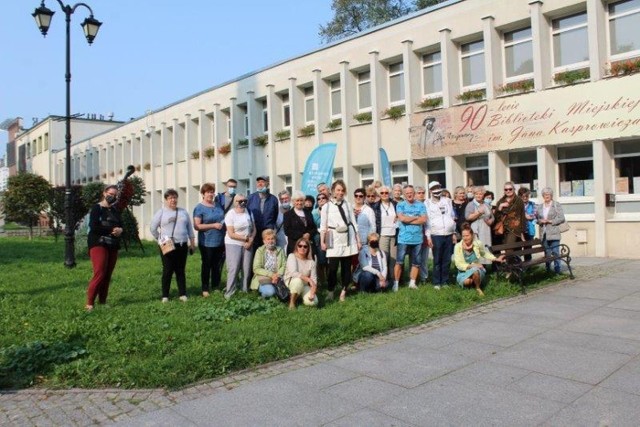 Początek spacer śladami Zygmunta Wilkońskiego. Jego uczestnicy pozują do fotografii przed gmachem inowrocławskiej biblioteki