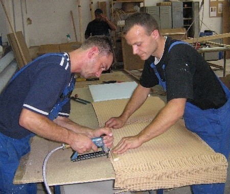 Robert Wachoński (z lewej) i Marcin Sokołowski obijają tkaniną loomową element łóżka (fot. Stefan Cieśla)