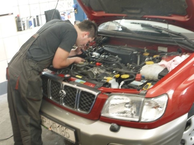 Pracownik firmy Auto Gaz System montuje instalację gazową.