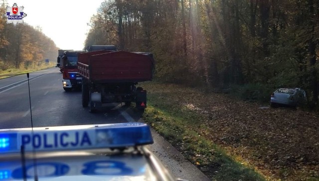 Rozbite auto stoi w rowie, na poboczu znajduje się ciągnik. Straż pożarna z policją są na miejscu