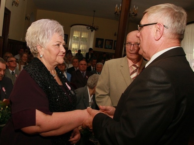 Burmistrz Tadeusz Dubicki (z prawej) gratuluje Teresie Łuczak (na pierwszym planie) oraz jej mężowi Marianowi.