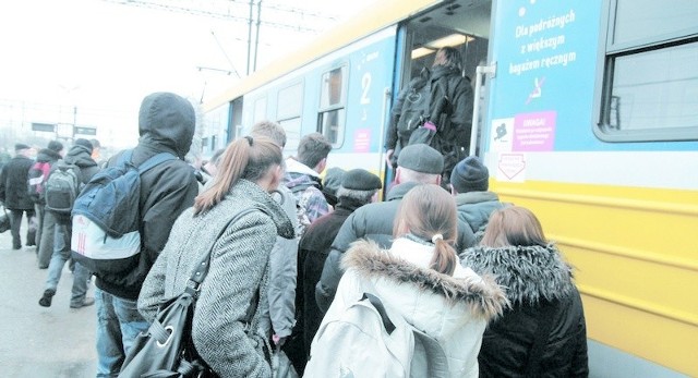 Podróżni wsiadający do pociągu na dworcu w Słupsku.