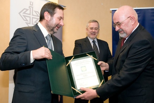 Prezes Stanisław Kłapeć (z prawej) obiera nagrodę dla swojego banku.
