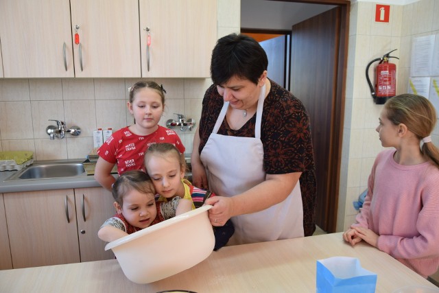 Danuta Podraza prowadząca zajęcia kulinarne w Dworku Koćmierzów tłumaczyła wszystkim, że podstawą dobrego i pulchnego ciasta na pączki jest jego odpowiednie wyrobienie.