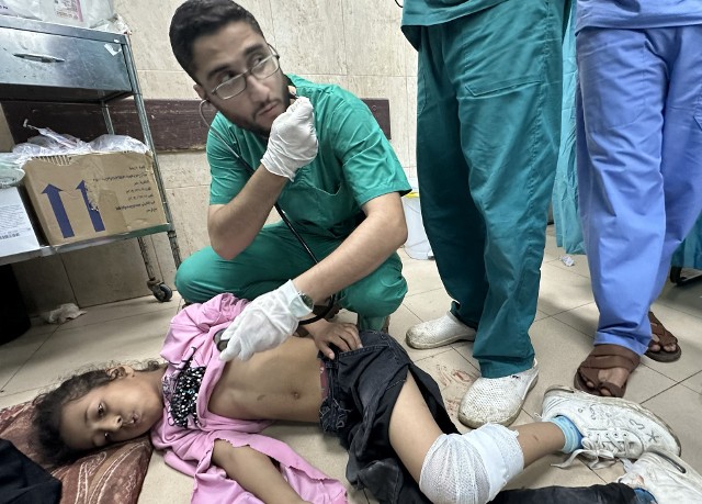 Lekarz opatruje ranną dziewczynkę po izraelskich atakach