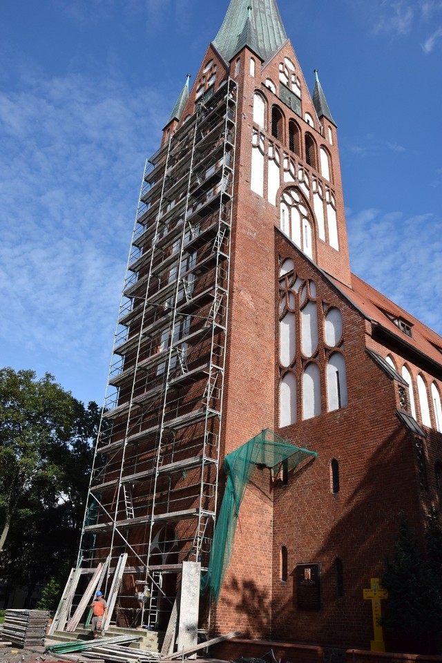 Wieża kościoła Mariackiego w Szczecinku przesłonięta rusztowaniem wraz z siatką zabezpieczającą