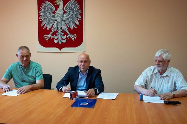 Starosta niżański Robert Bednarz (w środku) podpisuje umowę na modernizację dróg