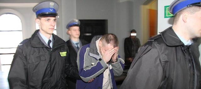 Policjanci wprowadzają na salę oskarżonych Sławomira B.