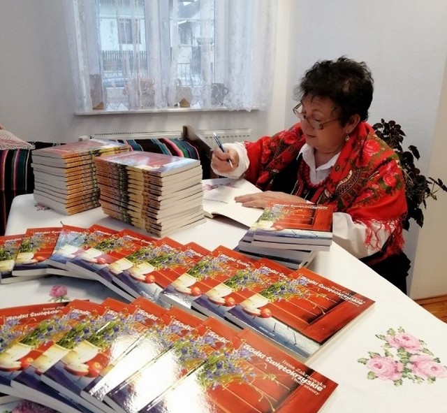 Irena Zakrzewska, członkini Koła Gospodyń Wiejskich „Osinianki” podpisuję swoja książkę „Godki Świętokrzyskie i inne utwory”