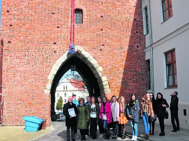 Uczniowie Collegium Gostomianum - uczestnicy akcji z jej koordynatorką, nauczycielką biologii Aleksandrą Stolą oraz burmistrzem Sandomierza Markiem Bronkowskim. Na bramie zawieszone warkocze.