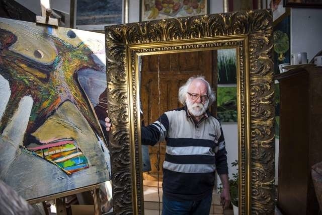 Wiesław Żyła prezentuje piękną ramę z początku XX wieku, którą jego znajomy znalazł na strychu domu przeznaczonego do rozbiórki