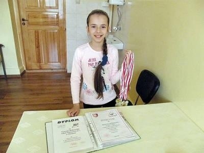 Krysia Mokrzycka cieszy się ze zdobytych medali i dyplomów Fot. Magdalena Uchto