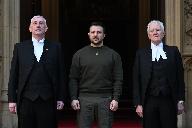 Prezydent Wołodomyr Zełenski powitany przez Lindsay'a Hoyle (z lewej), spikera Izby Gmin oraz Johna McFalla (z prawej), spikera Izby Lordów
