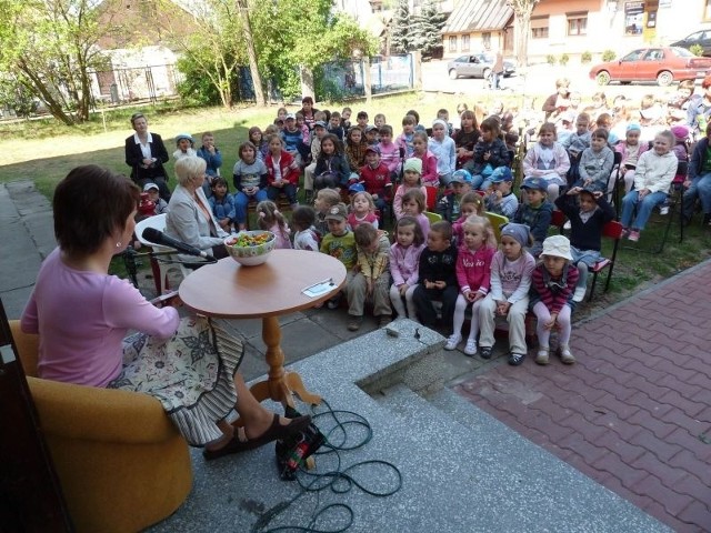 Przedszkolaki siedziały na trawniku przed biblioteką i wysłuchały fragmentów książki "Julek i Julka&#8221; Annie M.G. Schmidt.