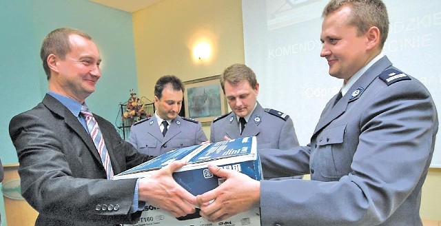Podinspektor Krzysztof Boguszewicz, zastępca komendanta powiatowego policji w Kołobrzegu, odbiera nagrodę za szybkie złapanie oszustki. Nagrodę wręcza starosta kołobrzeski, Artur Mackiewicz.