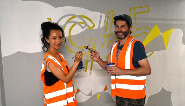 Paweł Ziemicki i Sara Sierra Rivera, autorzy muralu podczas pracy w przejściu podziemnym na stacji w Oświęcimiu