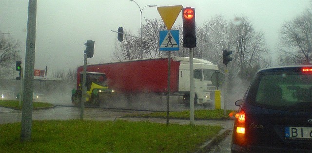 Walec wyrównuje świeży asfalt. Kierowcy czekają w korku.