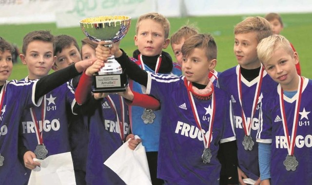 Młodzi piłkarze Wisły Kraków mieli największe powody do radości, wznosząc puchar za zwycięstwo