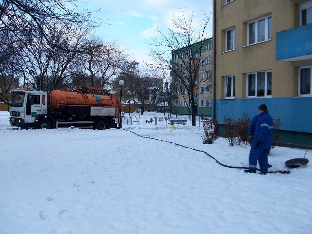 Pracownicy PWiK udrażniają zapchaną studzienkę. Kiedy topnieje śnieg, to często dochodzi do takich awarii.