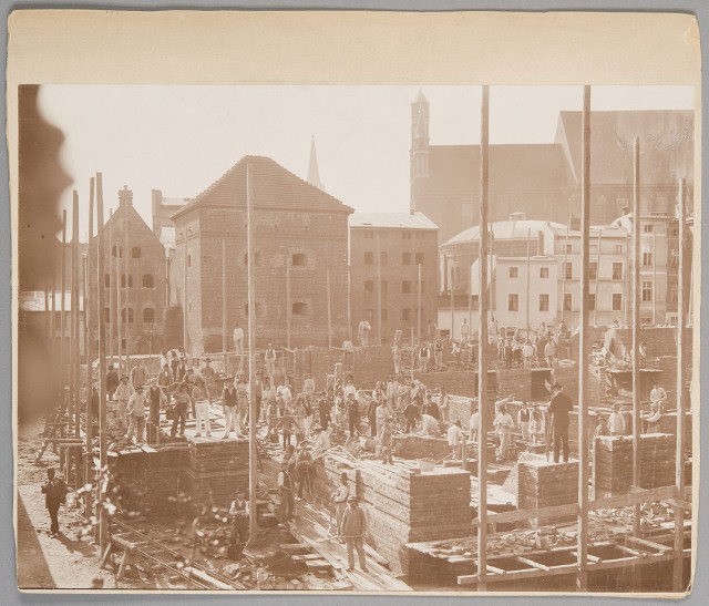 Budowa toruńskiego teatru rozpoczęła się w lipcu 1903 roku, na początku października mury były już na tyle wysokie, że spadający z nich robotnik poważnie się poranił. Mury pięły się do góry pomimo strajku, a także przerwy na zrobienie pamiątkowego zdjęcia, które tu widzimy.