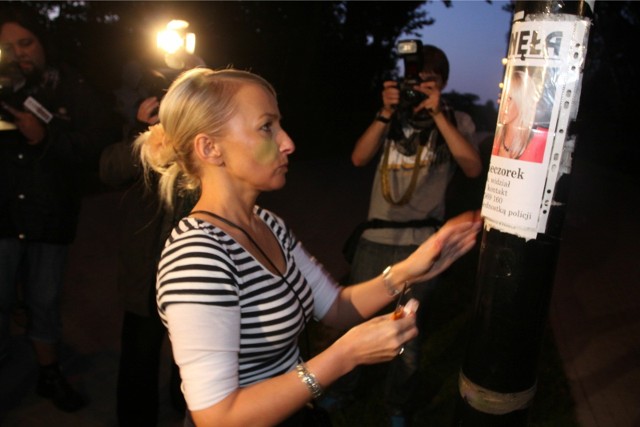 Iwona Kinda Wieczorek zawiesza plakat ogłoszenie o zaginięciu córki