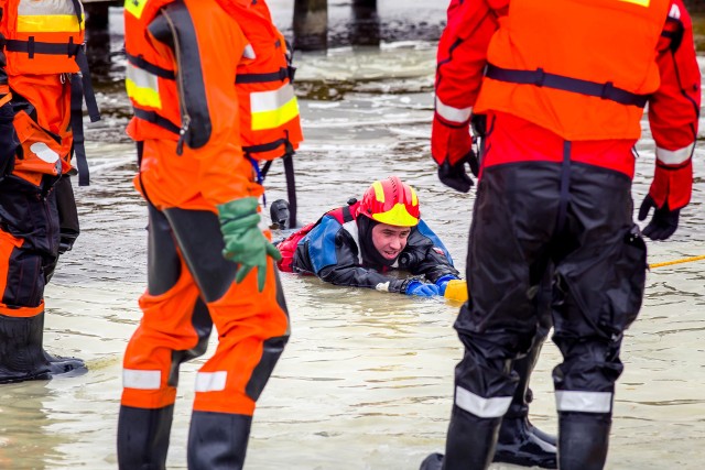 Ćwiczenia na lodzie na plaży Dojlidy w Białymstoku. Strażacy pokazywali m.in., jak przy pomocy specjalistycznego sprzętu ratowniczego wyciągnąć z wody tonącą osobę.