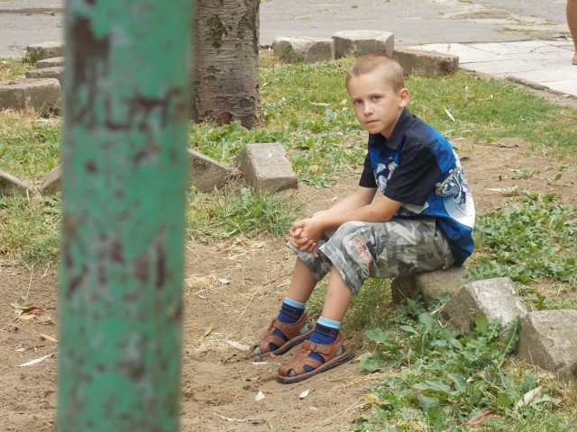 Ośmioletni Kuba chciałby mieć przy bloku piaskownicę. Dziś dzieci bawią się w starym piachu, który od trzech lat leży obok ulicy.