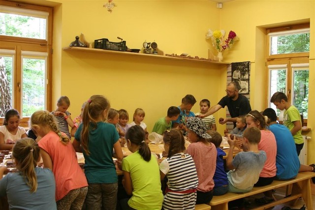 Michał Alzak, autor publikacji, prowadzi lekcję ceramiki dla dzieci z Wolanowa.