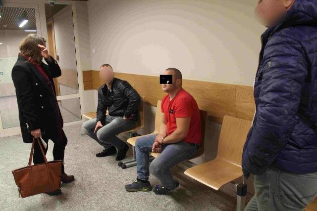 Obywatel Węgier Istvan N. pilnowany przez policjantów rozmawia z tłumaczką na korytarzu krakowskiego sądu