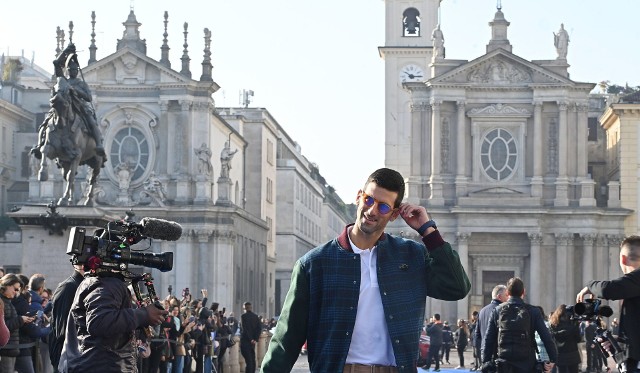 Djoković prezentujący się na niebieskim dywanie przed Nitto ATP Finals 2022 w Turynie