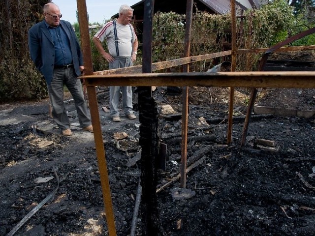 Jan Lis (z lewej), prezes Rodzinnego Ogrodu "Siarkopol&#8221; w Tarnobrzegu, a także Stanisław Surowiec, gospodarz ogrodu, przyglądają się zgliszczom dwóch spalonych altan działkowych.